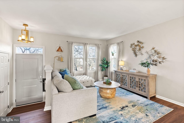 living room with dark hardwood / wood-style floors and a notable chandelier