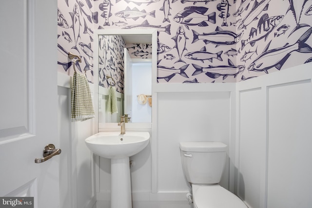 bathroom with toilet and wallpapered walls