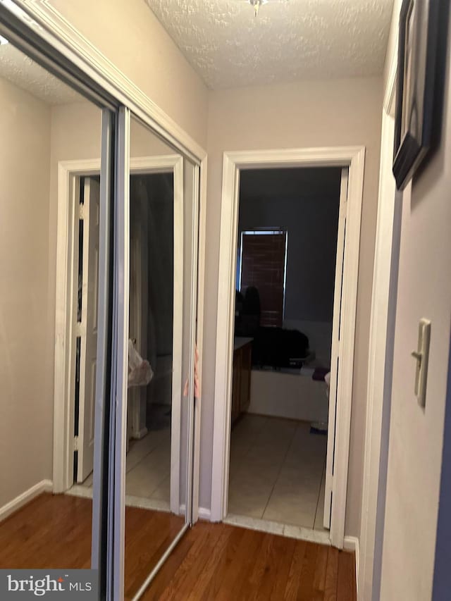 hallway featuring hardwood / wood-style floors and a textured ceiling