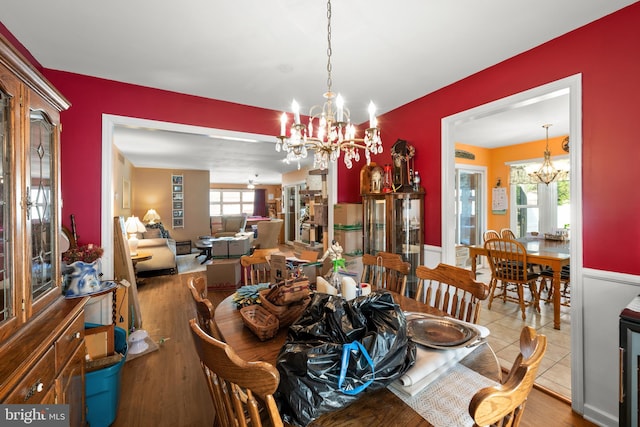 dining space featuring a healthy amount of sunlight, wood finished floors, and a notable chandelier