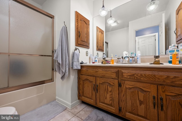 full bathroom featuring toilet, enclosed tub / shower combo, vanity, baseboards, and tile patterned floors