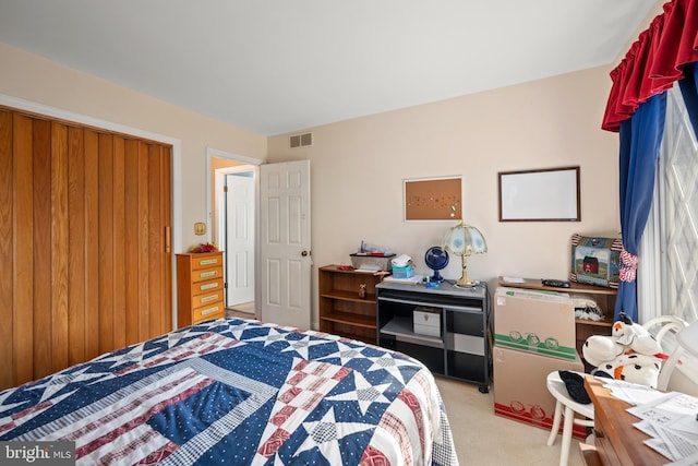 bedroom with a closet, visible vents, and light carpet