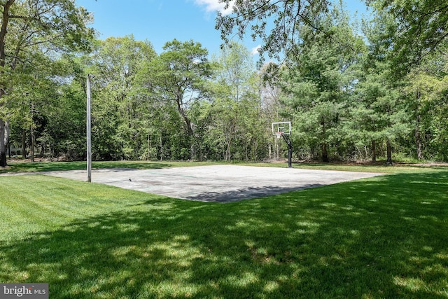 view of basketball court with community basketball court and a lawn