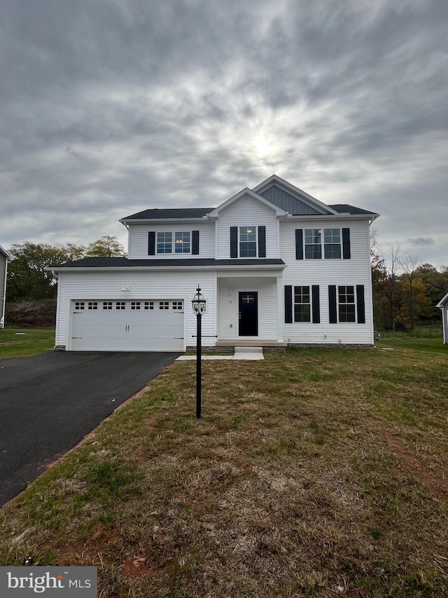 view of front property featuring a garage and a front lawn