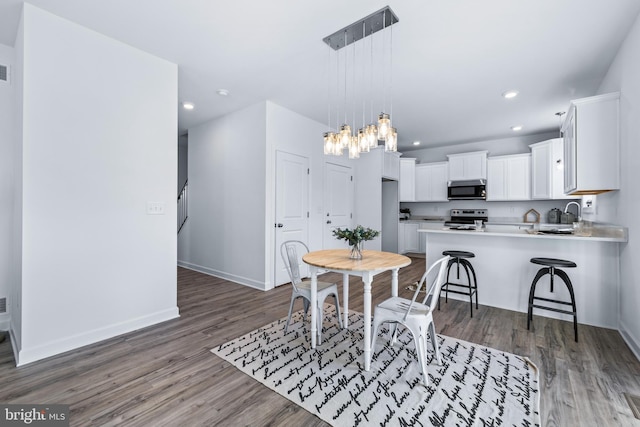 dining space featuring sink and dark hardwood / wood-style flooring