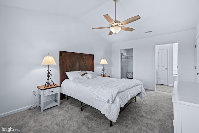 carpeted bedroom with lofted ceiling, a walk in closet, a closet, and ceiling fan