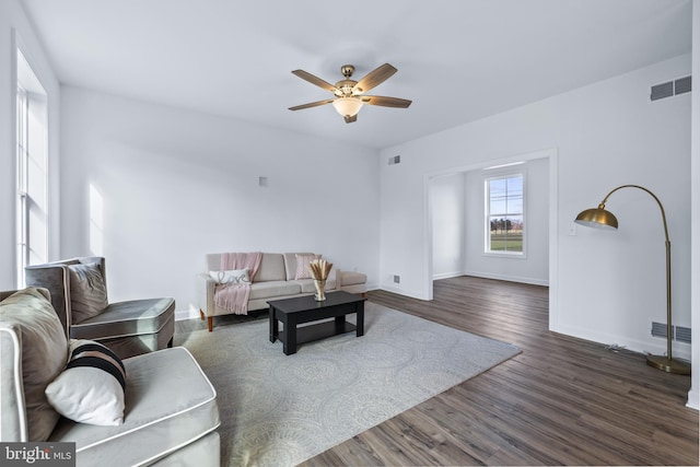 living room featuring ceiling fan and dark hardwood / wood-style floors