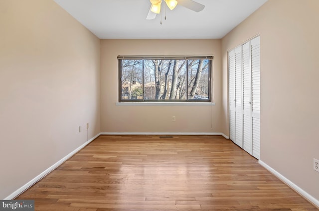 unfurnished bedroom with ceiling fan, a closet, and light wood-type flooring