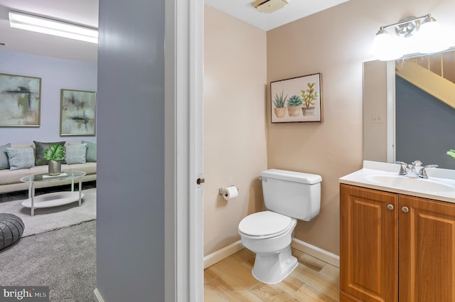 bathroom featuring hardwood / wood-style flooring, vanity, and toilet