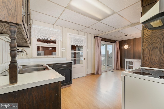 kitchen with a paneled ceiling, pendant lighting, sink, electric range, and light wood-type flooring