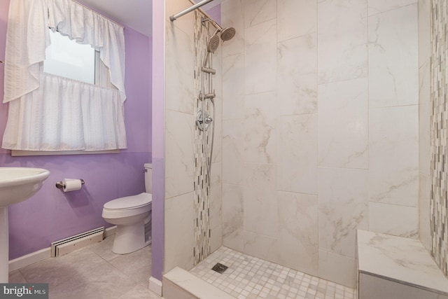 bathroom featuring tiled shower, tile patterned floors, toilet, and a baseboard heating unit