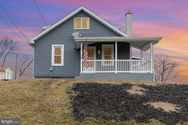 view of front facade with a porch and a lawn