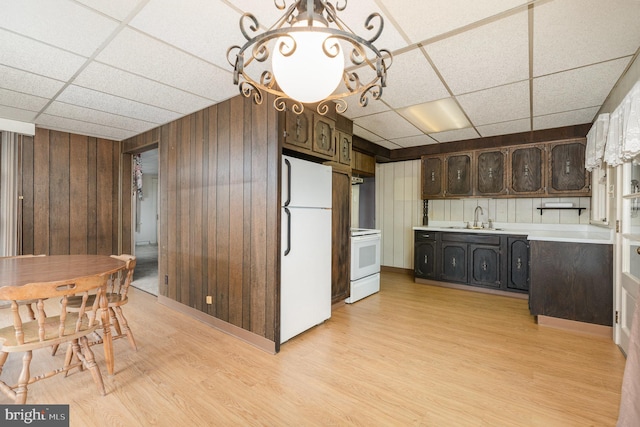 kitchen with sink, white fridge, range, light hardwood / wood-style floors, and dark brown cabinets