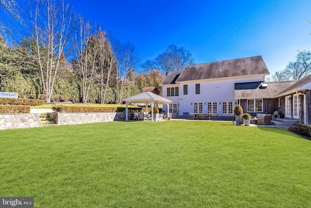 rear view of house featuring outdoor lounge area, a gazebo, french doors, a lawn, and a patio area