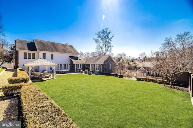 rear view of house featuring a patio area and a lawn