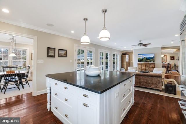 kitchen featuring dark wood-style floors, dark countertops, and crown molding