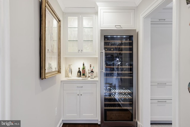 bar featuring beverage cooler, a dry bar, and ornamental molding