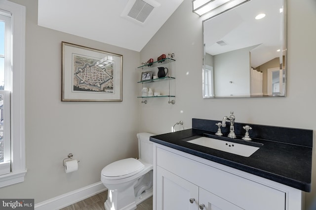 bathroom featuring visible vents, vaulted ceiling, vanity, and toilet