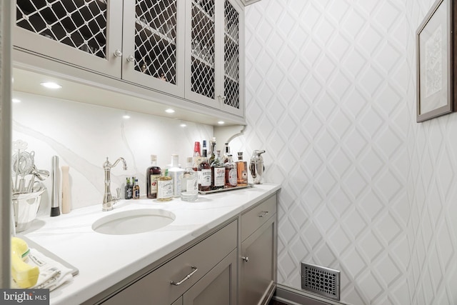 bar with a sink, visible vents, and bar area