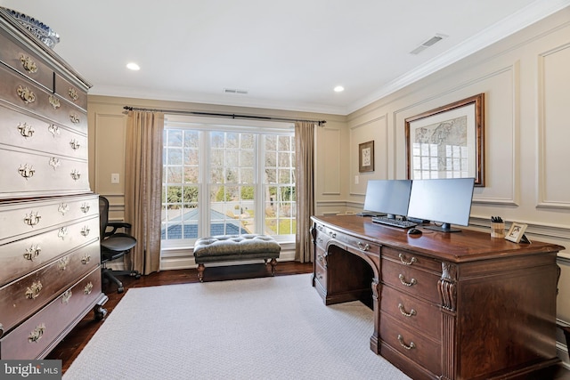 office space featuring crown molding, dark wood finished floors, visible vents, and a decorative wall