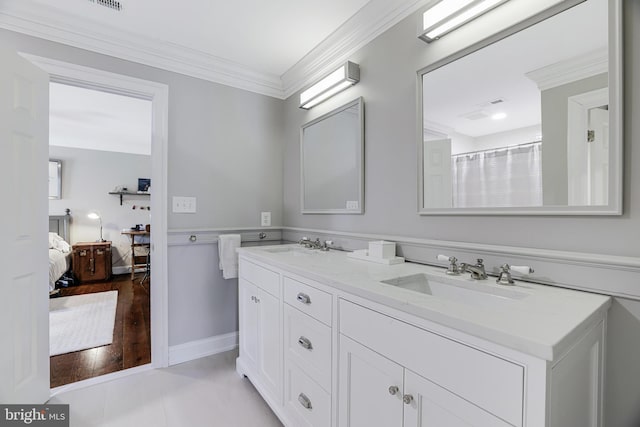 ensuite bathroom featuring double vanity, ensuite bathroom, ornamental molding, a sink, and baseboards