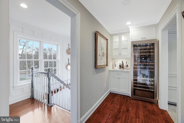 bar featuring recessed lighting, beverage cooler, baseboards, dark wood-style floors, and a bar