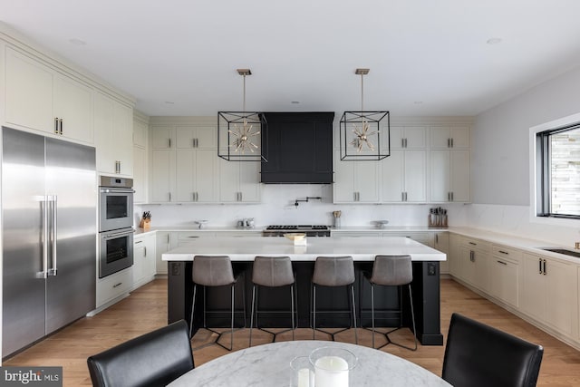 kitchen featuring appliances with stainless steel finishes, a breakfast bar, hanging light fixtures, and a kitchen island