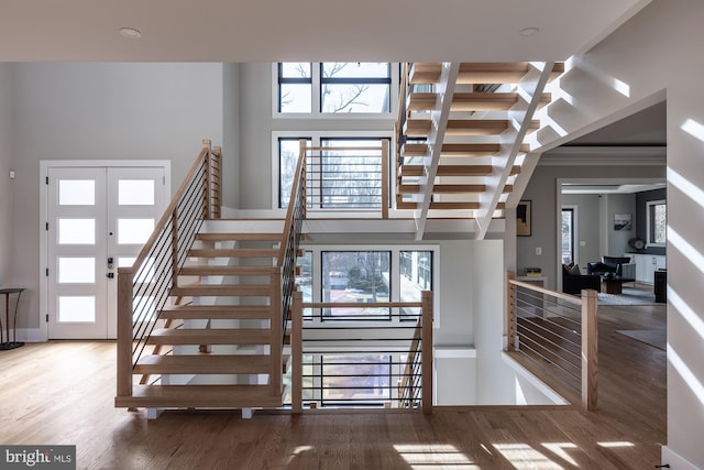 stairs with a towering ceiling and hardwood / wood-style floors