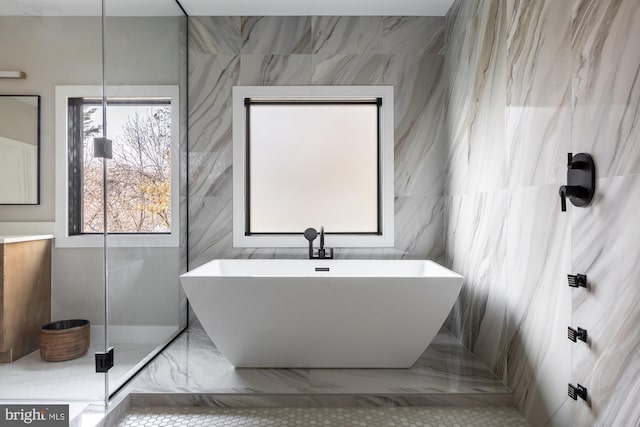 bathroom featuring shower with separate bathtub, tile walls, and vanity