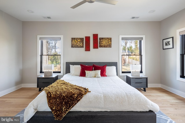 bedroom featuring multiple windows, ceiling fan, and light wood-type flooring