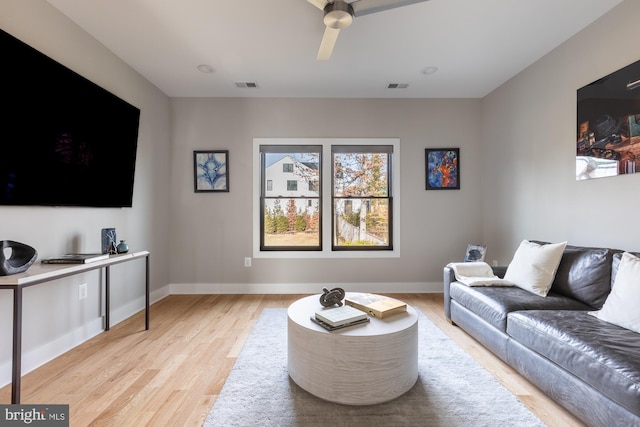 living room featuring ceiling fan and light hardwood / wood-style floors