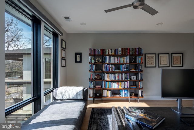 sitting room with hardwood / wood-style floors and ceiling fan