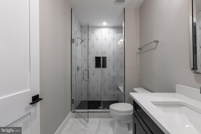 bathroom featuring vanity, toilet, a shower with shower door, and tile patterned flooring