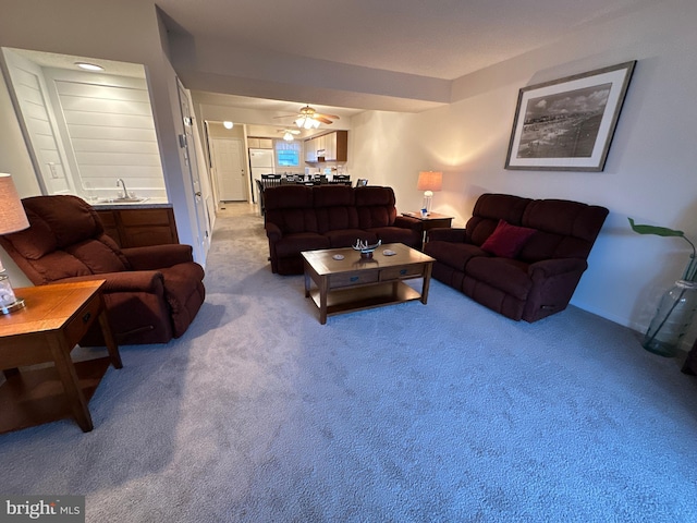 carpeted living room featuring sink and ceiling fan