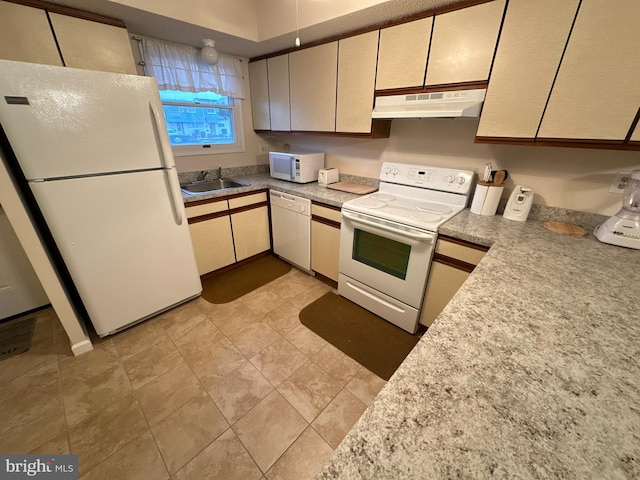 kitchen with cream cabinets, sink, and white appliances