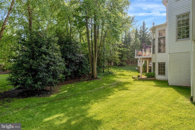 view of green lawn featuring a deck