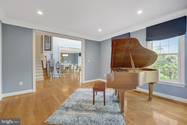 living area featuring recessed lighting, baseboards, light wood finished floors, crown molding, and stairway