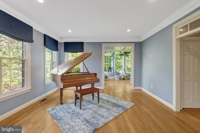 sitting room featuring ornamental molding, visible vents, plenty of natural light, and light wood-style floors