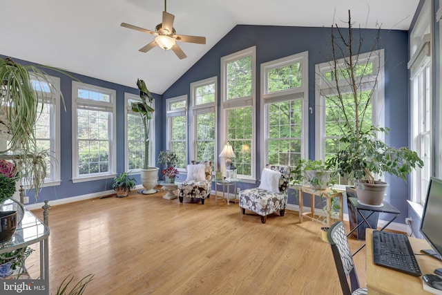 sunroom featuring wood finished floors, vaulted ceiling, and baseboards