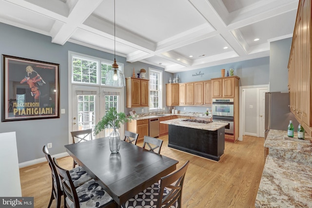 dining room featuring coffered ceiling, light wood finished floors, beamed ceiling, baseboards, and a towering ceiling