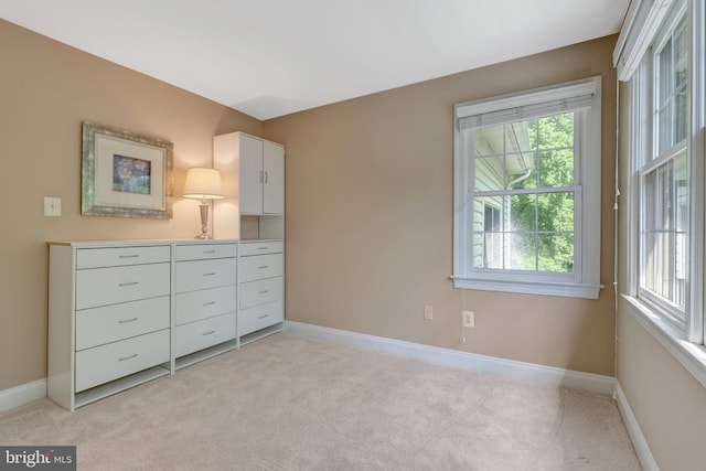 unfurnished bedroom with light carpet and baseboards