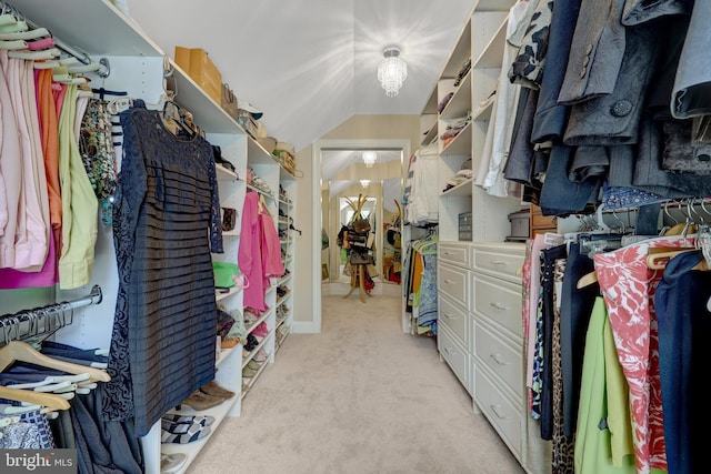 walk in closet featuring light carpet and lofted ceiling