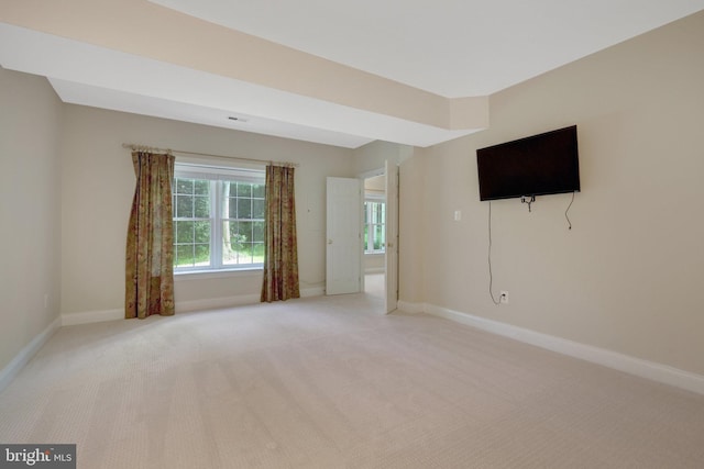unfurnished room featuring light carpet and baseboards