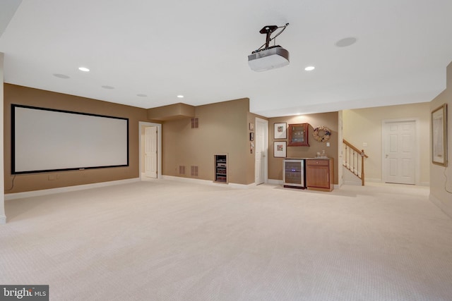 cinema room with wine cooler, baseboards, bar, light carpet, and recessed lighting