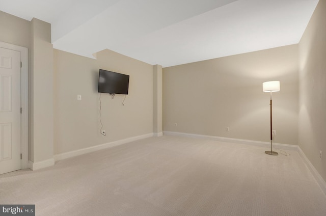 unfurnished living room with light colored carpet and baseboards