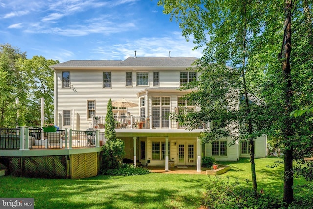 rear view of house with a deck and a lawn