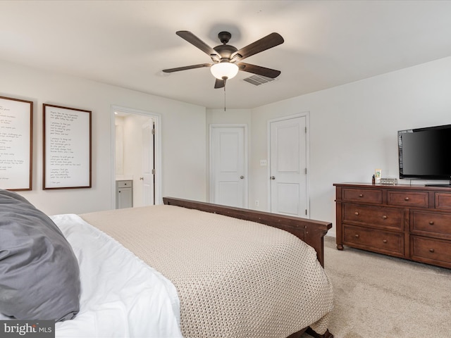 bedroom featuring connected bathroom, light colored carpet, and ceiling fan