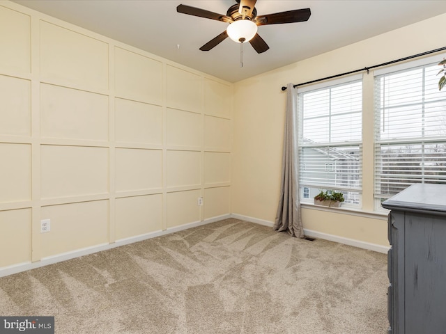 carpeted spare room with ceiling fan