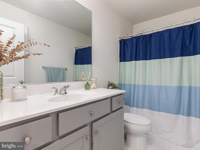 bathroom with tile patterned flooring, vanity, and toilet