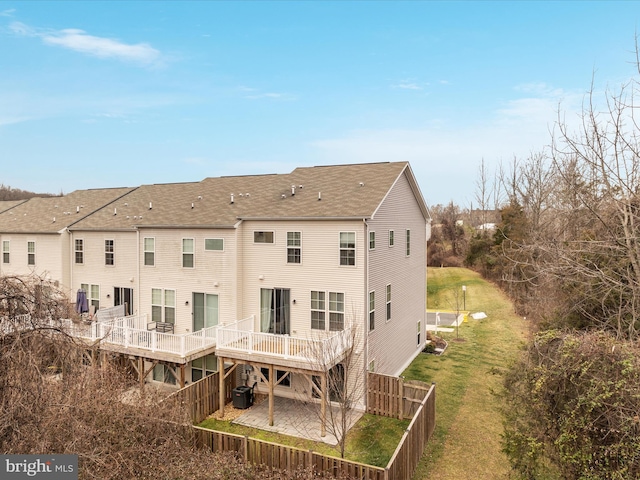 back of property with cooling unit, a wooden deck, a lawn, and a patio